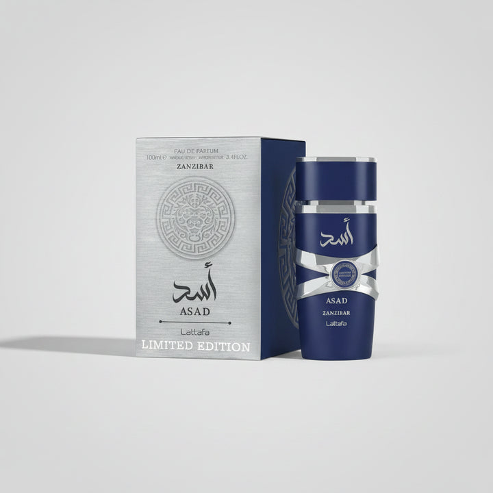 Blue perfume bottle with silver cap and 'Asad' branding next to its packaging on a white background