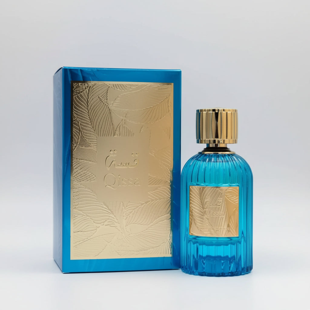A blue ribbed glass perfume bottle with a gold cap stands next to its matching blue and gold box on a white background.
